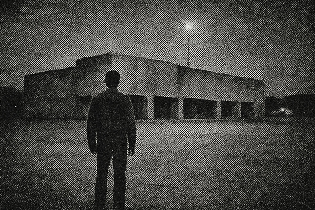 A lone man at dawn facing a strange mall at the edge of town, grainy halftone press photo